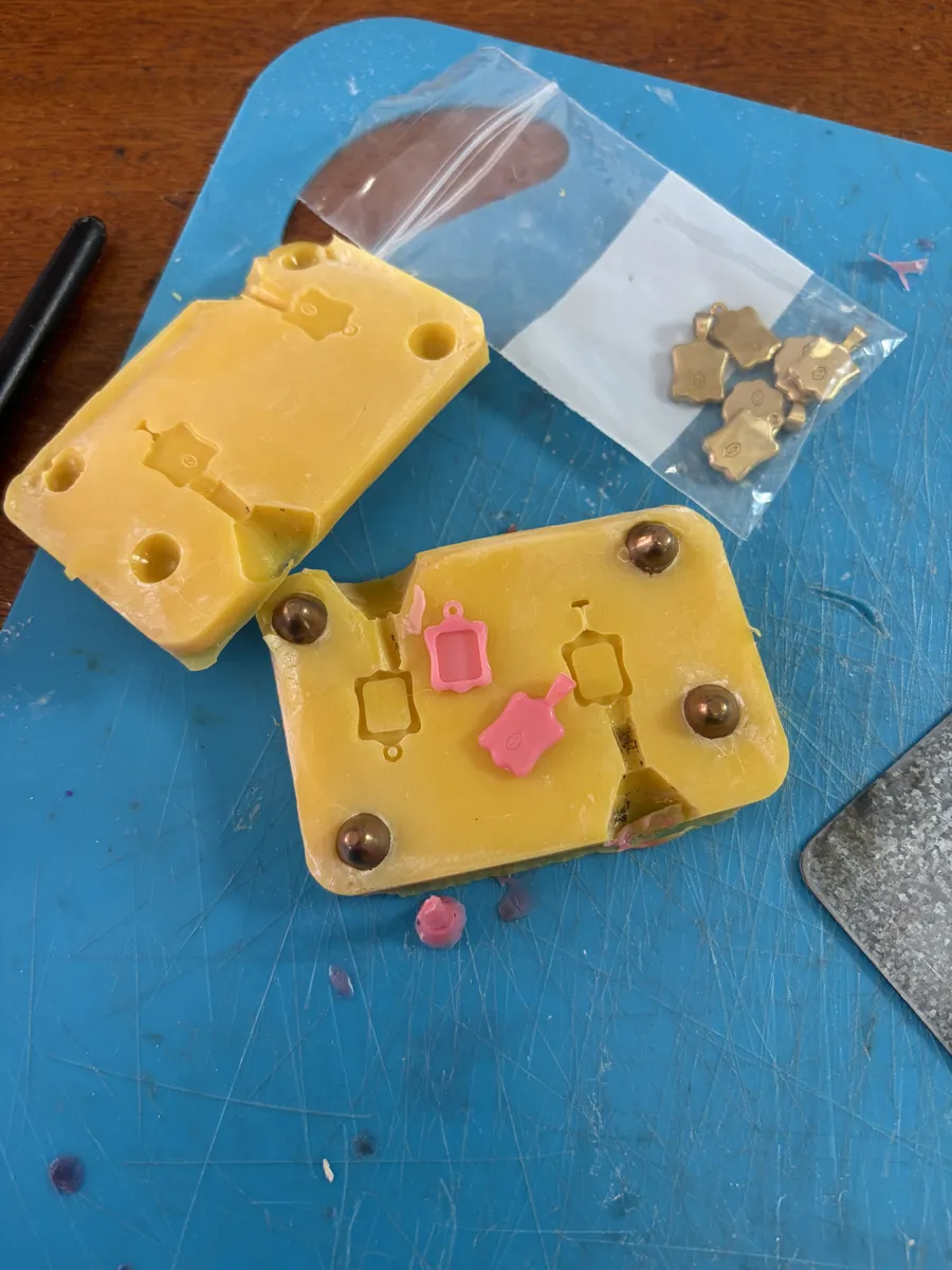 The opened mold with pink wax copies