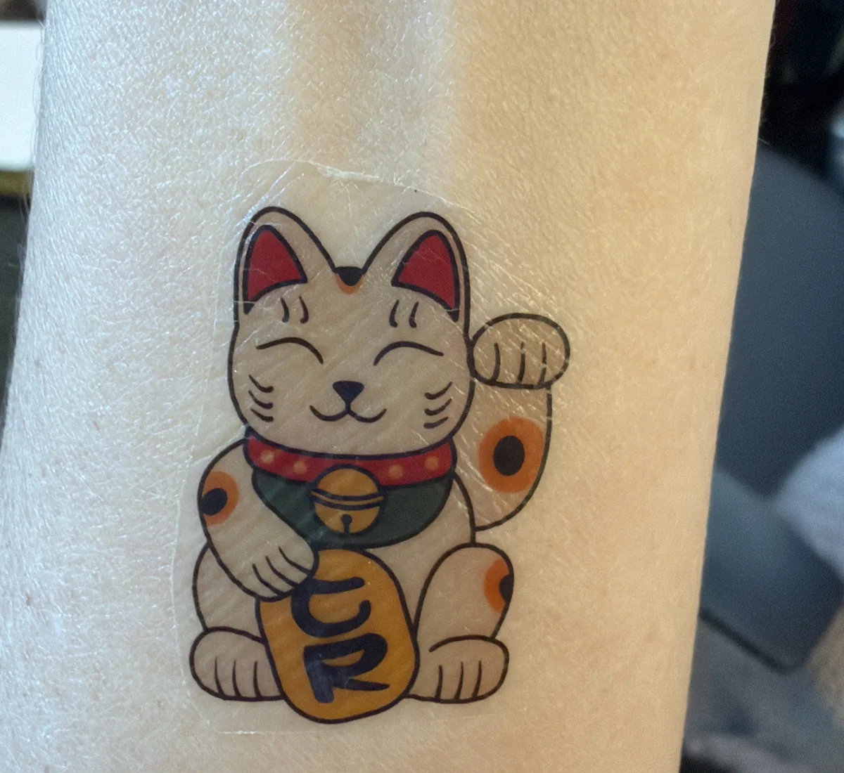 The lucky cat tattoo worn on an arm